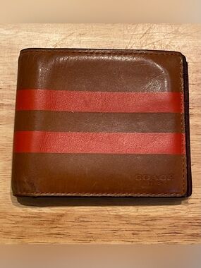 men's wallet featuring the "COACH NEW YORK" stamp and the Varsity Stripe.